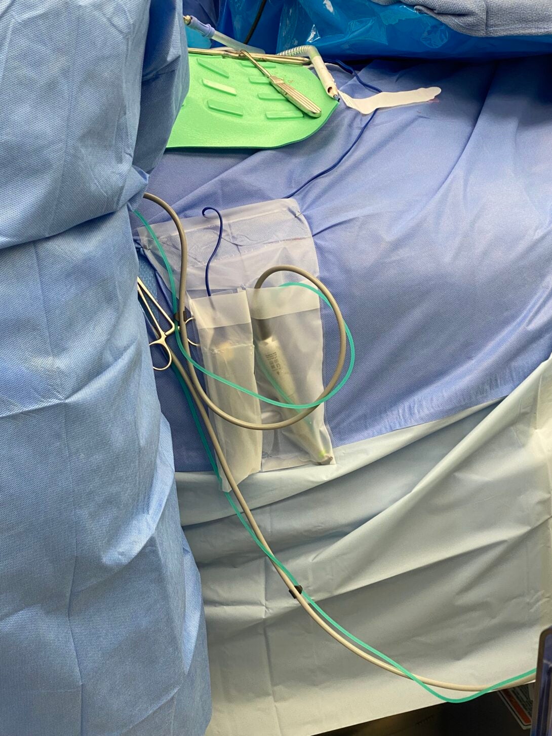 Image of the surgical pouch connected to the table with a surgeon (left)